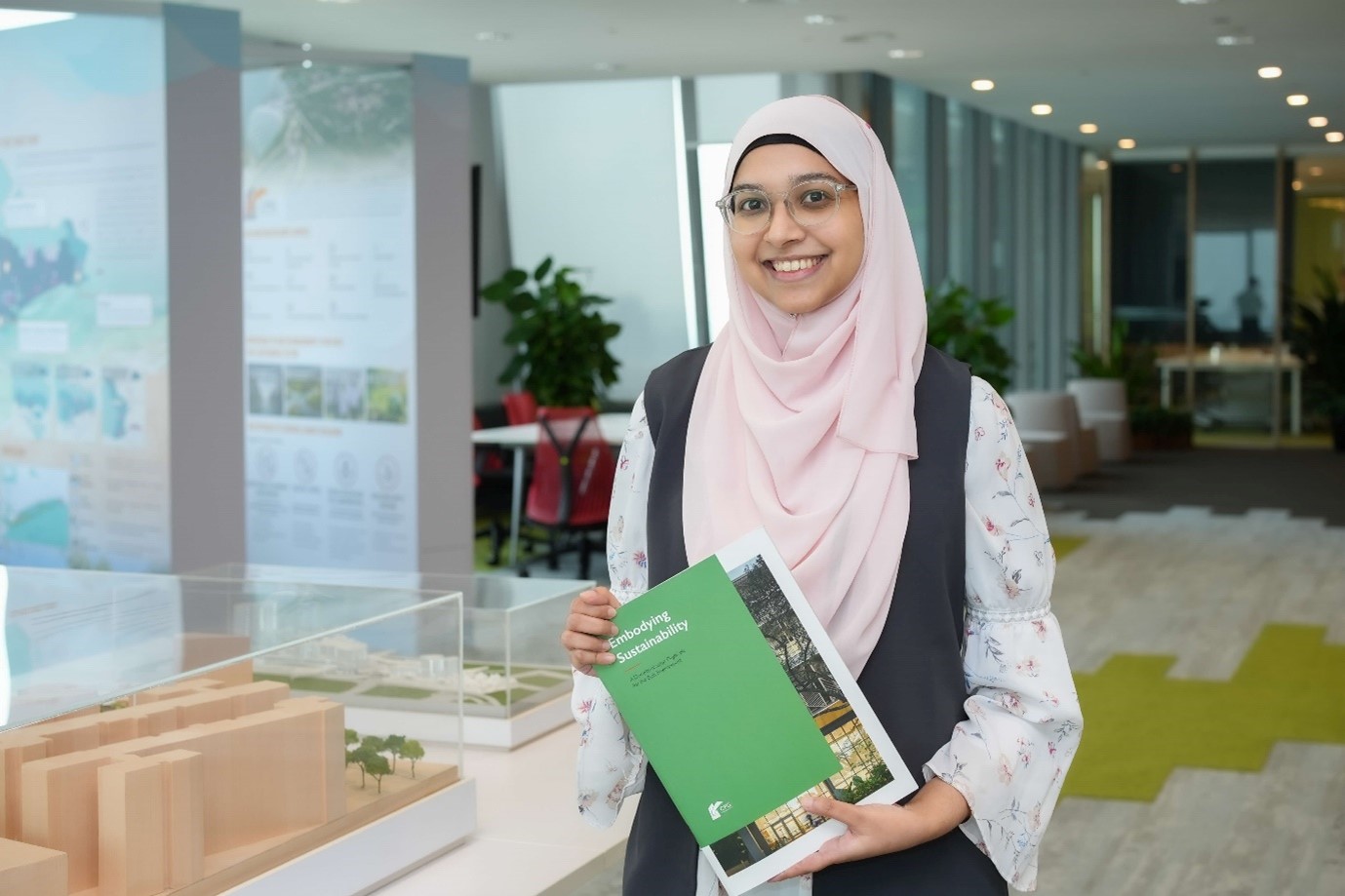Rabia holding the “Embodying Sustainability” publication, by CPG Corporation