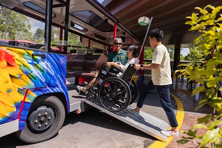 Photo of a wheelchair user being assisted onto shuttle